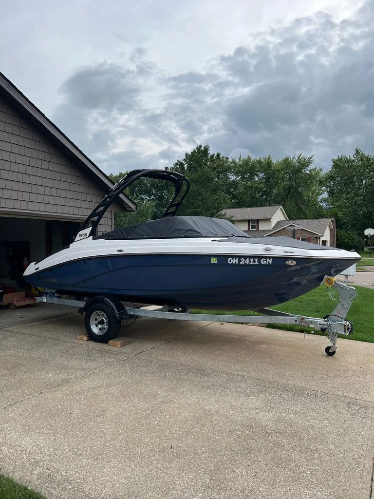 The Image of 2024 Yamaha Boats 195S parked on trailer in driveway. - 0