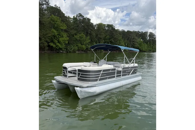 The Image of 2023 Godfrey Sweetwater 2286 C pontoon boat on a serene lake. - 1