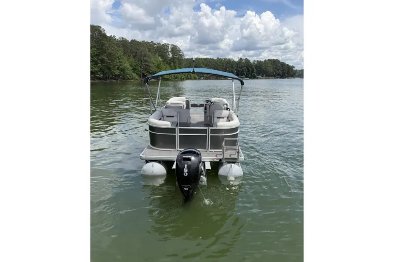 Slide: The Image of 2023 Godfrey Sweetwater 2286 C pontoon boat on a serene lake. - 4