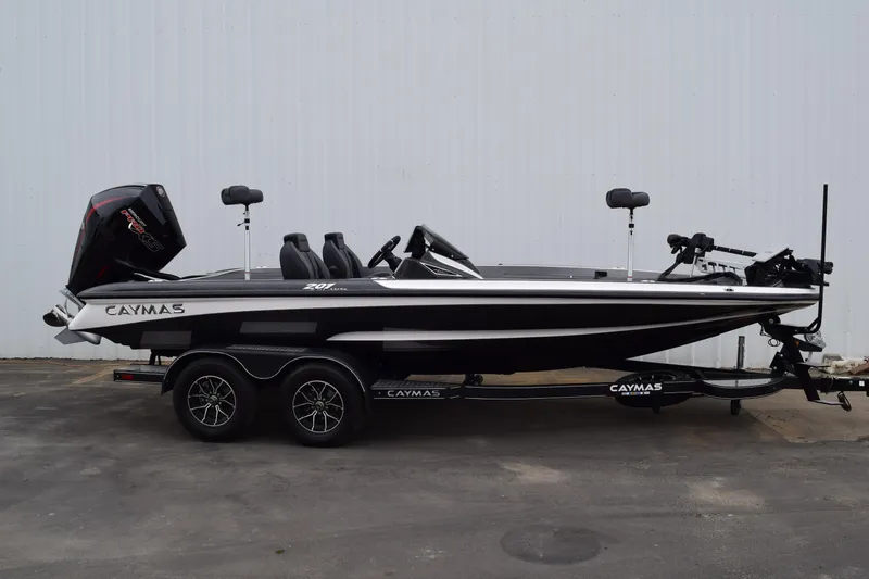 The Image of 2027 Caymas 201 Pro boat with dual axle trailer, black and white design, parked outdoors. - 1