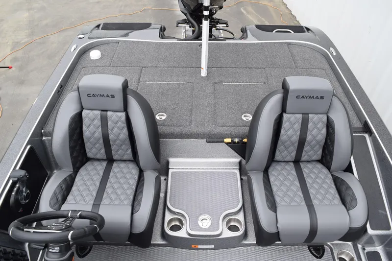Slide: The Image of 2027 Caymas 201 Pro boat interior with two gray quilted seats and steering wheel. - 16