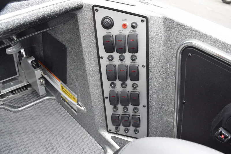 Slide: The Image of Control panel of 2027 Caymas 201 Pro boat with switches and labels. - 24