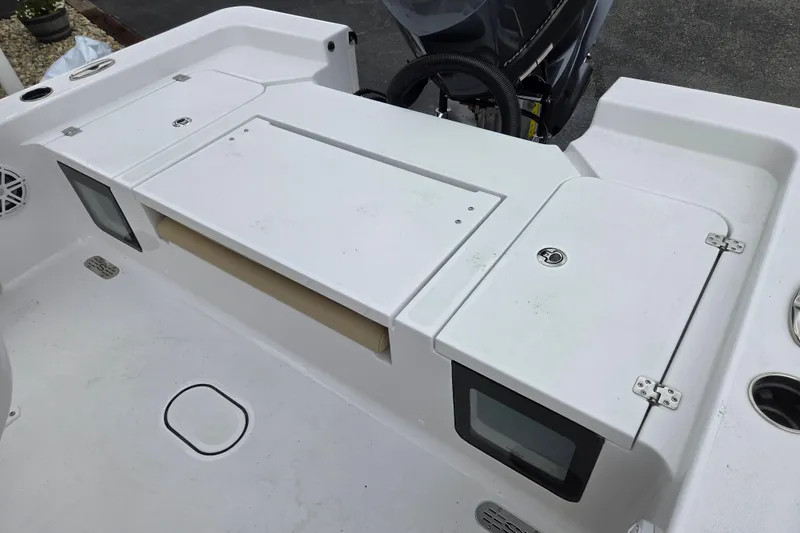 Slide: The Image of 2026 Sportsman Masters 227 Bay Boat deck with storage compartments and control panel. - 10