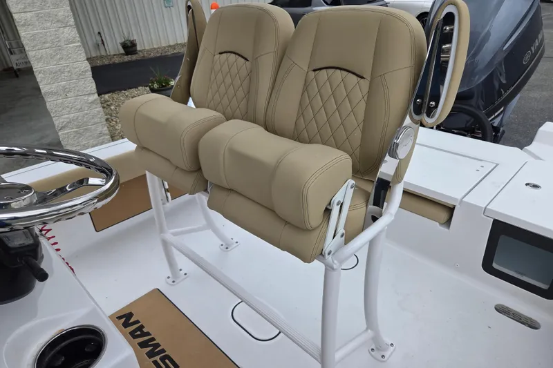 Slide: The Image of 2026 Sportsman Masters 227 Bay Boat with beige cushioned seating and steering wheel. - 16
