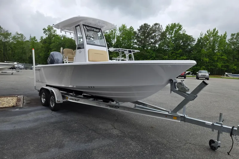 Slide: The Image of 2026 Sportsman Masters 227 Bay Boat on trailer, parked outdoors with trees in background. - 5
