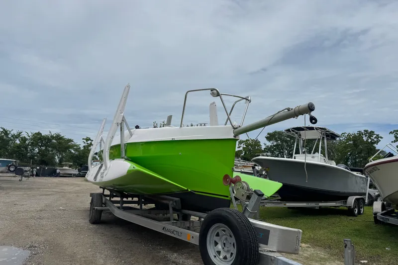 Slide: The Image of Bright green Corsair 760R boat on trailer, 2019 model, parked outdoors under cloudy sky. - 2