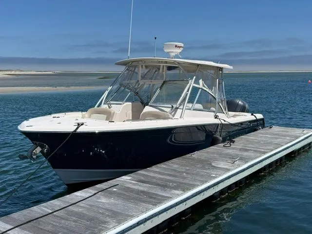 Slide: The Image of 2013 Grady-White Freedom 285 boat docked on calm water. - 2