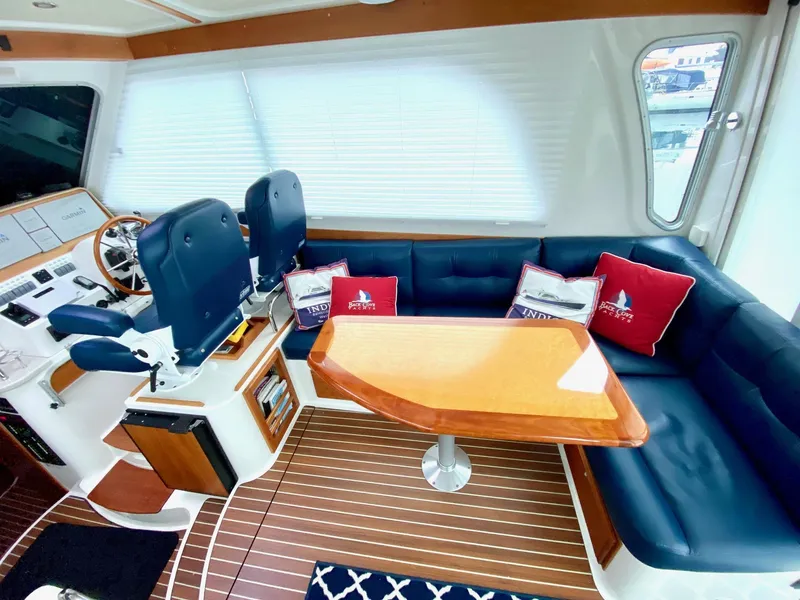 Slide: The Image of Interior of a 2017 Back Cove 37 yacht with blue seating and wooden table. - 23