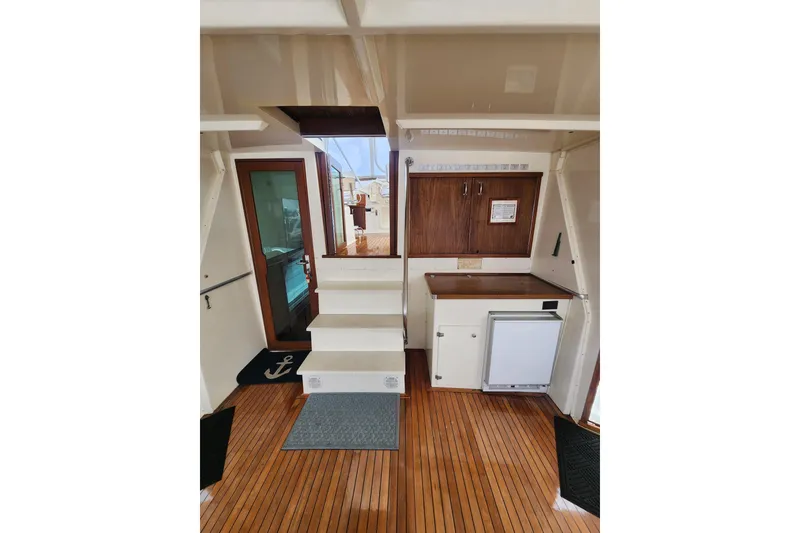Slide: The Image of Interior of 1983 Hatteras 48 Motor Yacht with wooden flooring and compact kitchenette. - 12