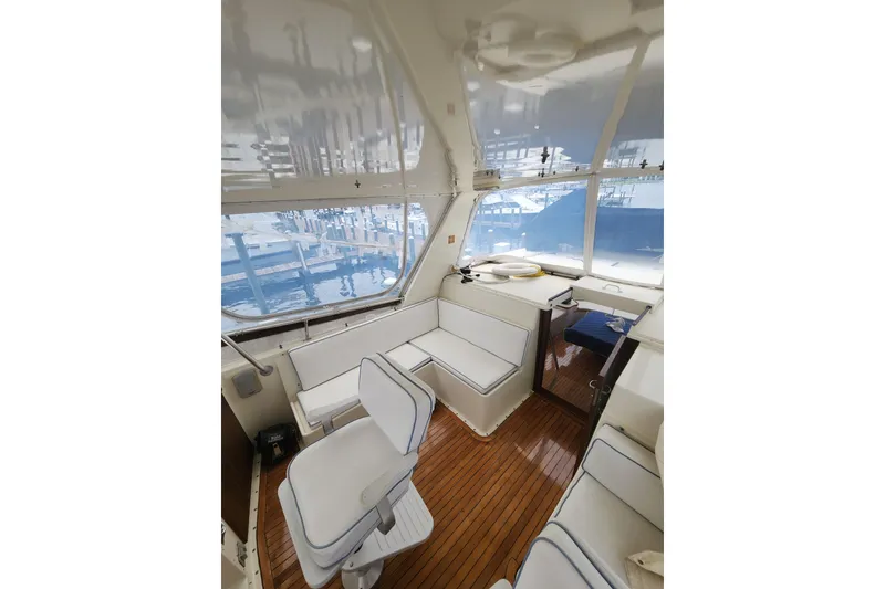 Slide: The Image of Interior of 1983 Hatteras 48 Motor Yacht with white seating and wooden flooring. - 14