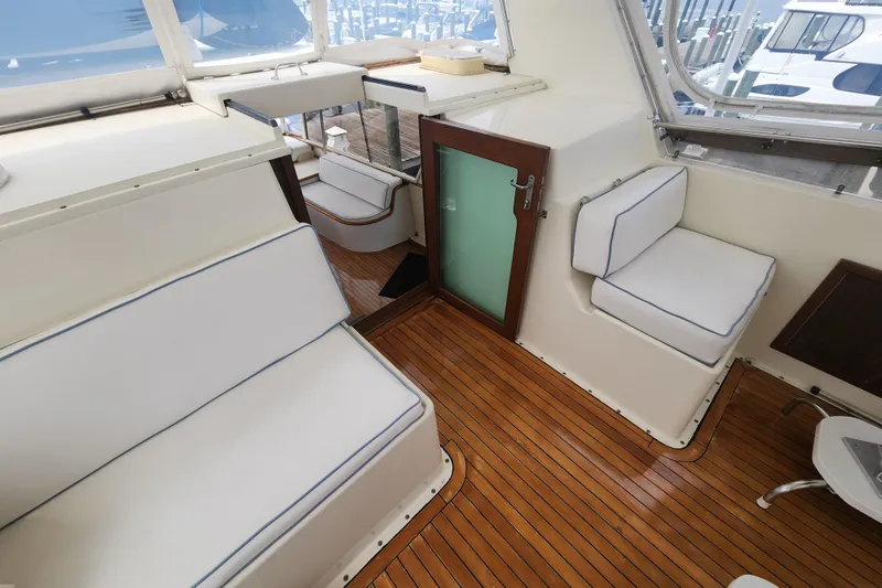 Slide: The Image of 1983 Hatteras 48 Motor Yacht interior with white seating and wooden flooring. - 15