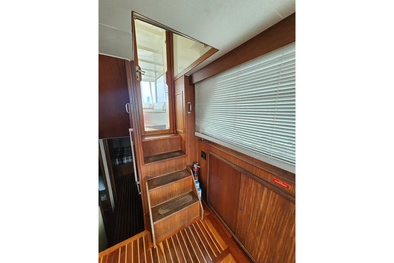 Slide: The Image of Interior stairs of 1983 Hatteras 48 Motor Yacht with wooden finish and blinds. - 17