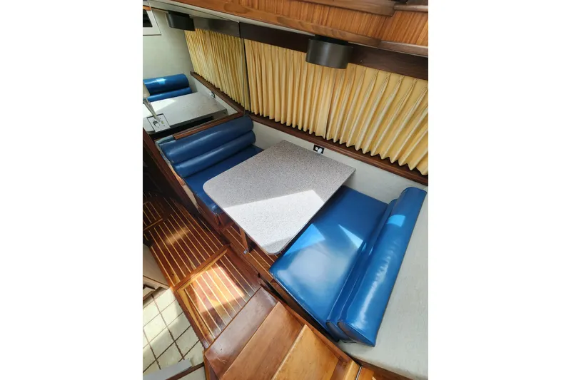 Slide: The Image of Interior of 1983 Hatteras 48 Motor Yacht with blue seating and wooden flooring. - 22