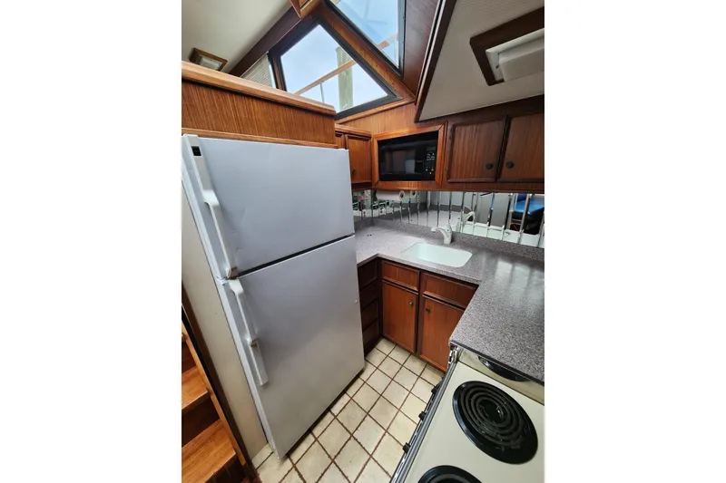 Slide: The Image of Kitchen area of 1983 Hatteras 48 Motor Yacht with appliances and wooden cabinetry. - 24