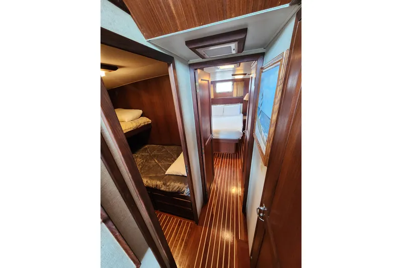 Slide: The Image of Interior of 1983 Hatteras 48 Motor Yacht with wood paneling and cozy sleeping quarters. - 26