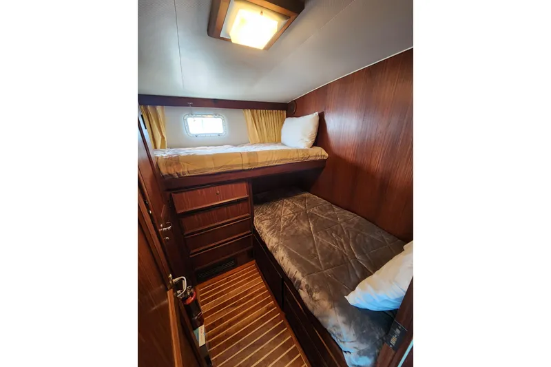 Slide: The Image of 1983 Hatteras 48 Motor Yacht cabin with wooden interior and bunk beds. - 27