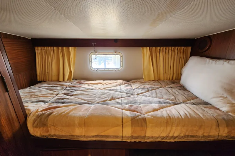 Slide: The Image of Cozy cabin bed in 1983 Hatteras 48 Motor Yacht with window and yellow curtains. - 29