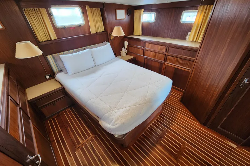 Slide: The Image of Cozy bedroom interior of 1983 Hatteras 48 Motor Yacht with wood paneling and double bed. - 30