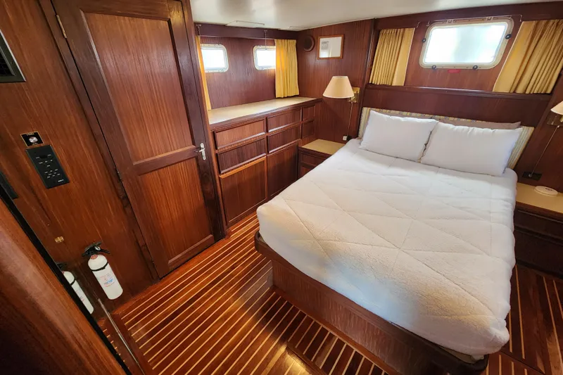 Slide: The Image of Cozy bedroom interior of 1983 Hatteras 48 Motor Yacht with wood paneling and double bed. - 32