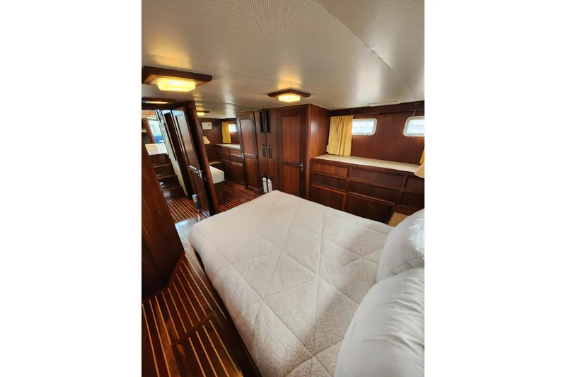 Slide: The Image of Luxurious cabin interior of 1983 Hatteras 48 Motor Yacht with wood paneling and cozy bedding. - 33