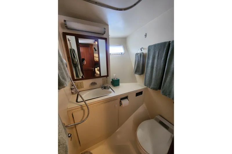 Slide: The Image of Bathroom interior of 1983 Hatteras 48 Motor Yacht with sink, mirror, and towels. - 38