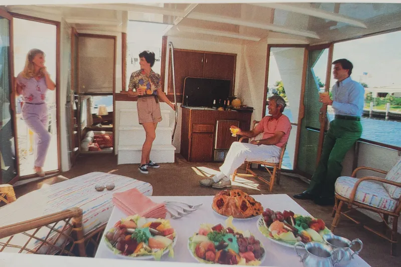 Slide: The Image of Group enjoying leisure time on a 1983 Hatteras 48 Motor Yacht with snacks and drinks. - 44