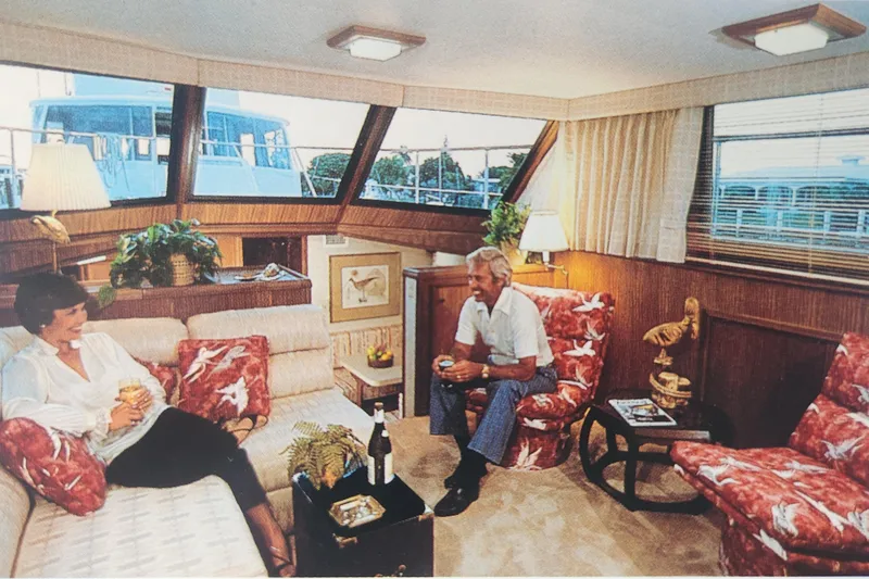 Slide: The Image of Interior of 1983 Hatteras 48 Motor Yacht with people relaxing in the lounge area. - 46