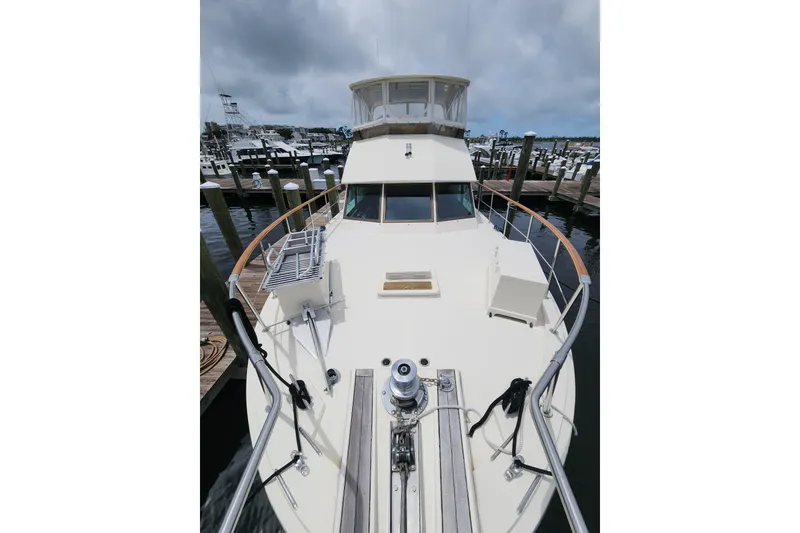 Slide: The Image of 1983 Hatteras 48 Motor Yacht docked at marina under cloudy sky. - 5