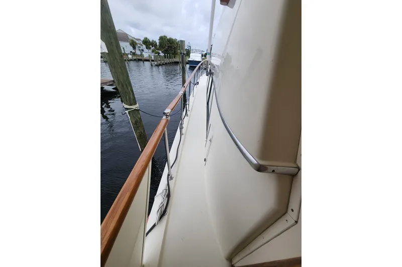 Slide: The Image of 1983 Hatteras 48 Motor Yacht deck view with railing, docked by water. - 9