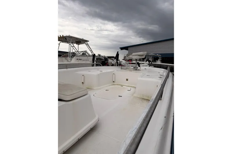 Slide: The Image of 2004 Fishmaster 24 boat with open deck, under cloudy sky. - 6