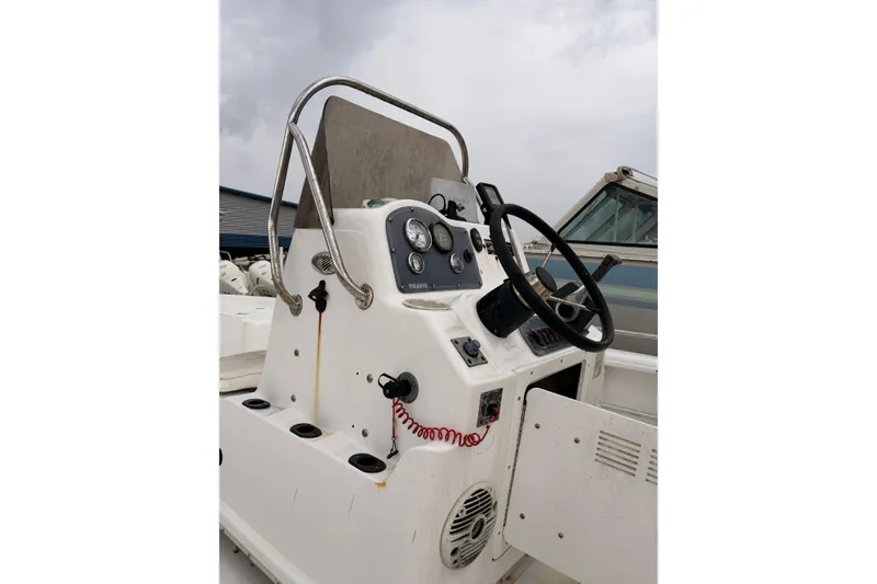 Slide: The Image of 2004 Fishmaster 24 boat console with steering wheel and gauges under cloudy sky. - 7