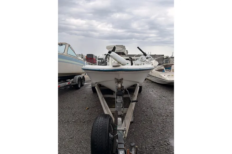 Slide: The Image of 2004 Fishmaster 24 boat on trailer under cloudy sky. - 1
