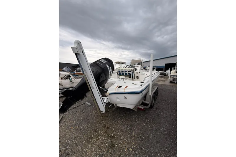 Slide: The Image of 2004 Fishmaster 24 boat on trailer under cloudy sky. - 4