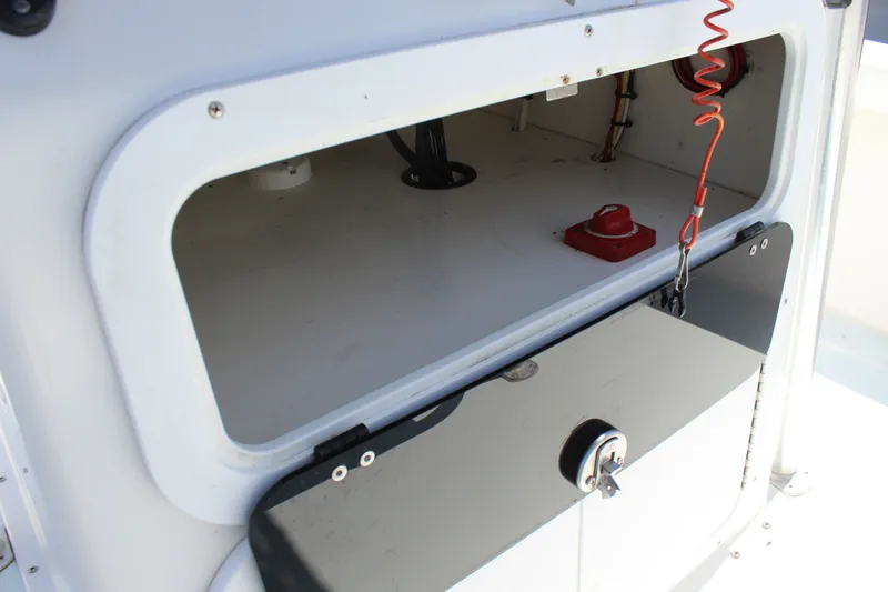 Slide: The Image of 2023 Intruder 23 boat, open storage compartment with red switch. - 22
