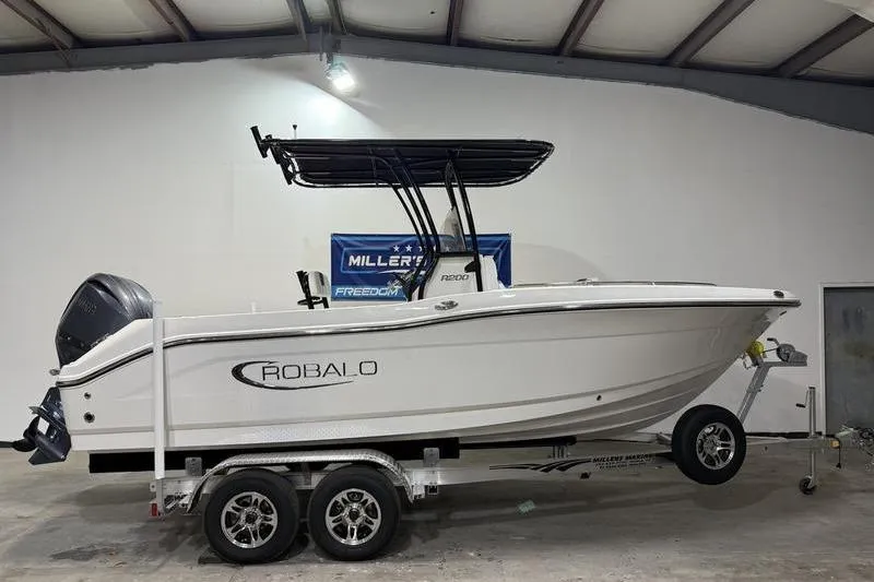 The Image of 2026 Robalo R200 Center Console boat on trailer in indoor showroom. - 0