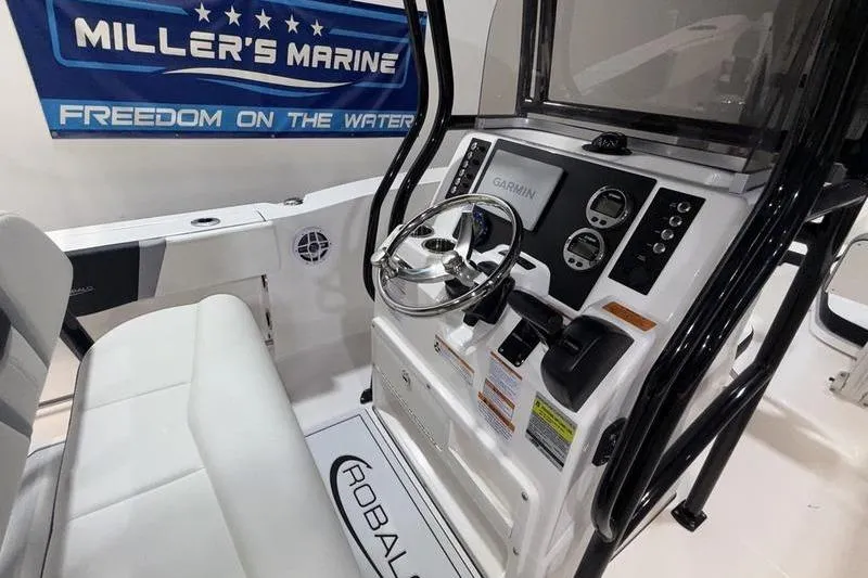 Slide: The Image of 2026 Robalo R200 Center Console boat interior with steering wheel and Garmin display. - 12