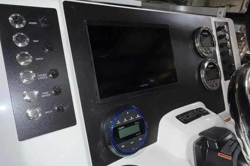 Slide: The Image of 2026 Robalo R200 Center Console dashboard with Garmin display and control switches. - 14