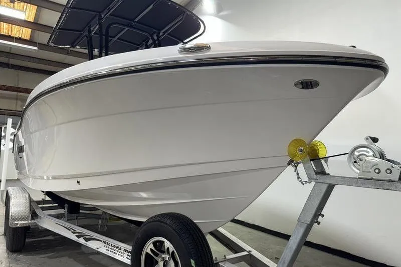 Slide: The Image of 2026 Robalo R200 Center Console boat on trailer in indoor storage. - 2