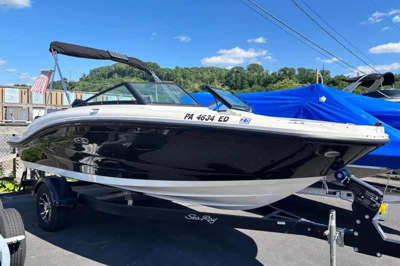The Image of 2022 Sea Ray SPX 190 Outboard boat on trailer, black and white design, sunny day. - 0
