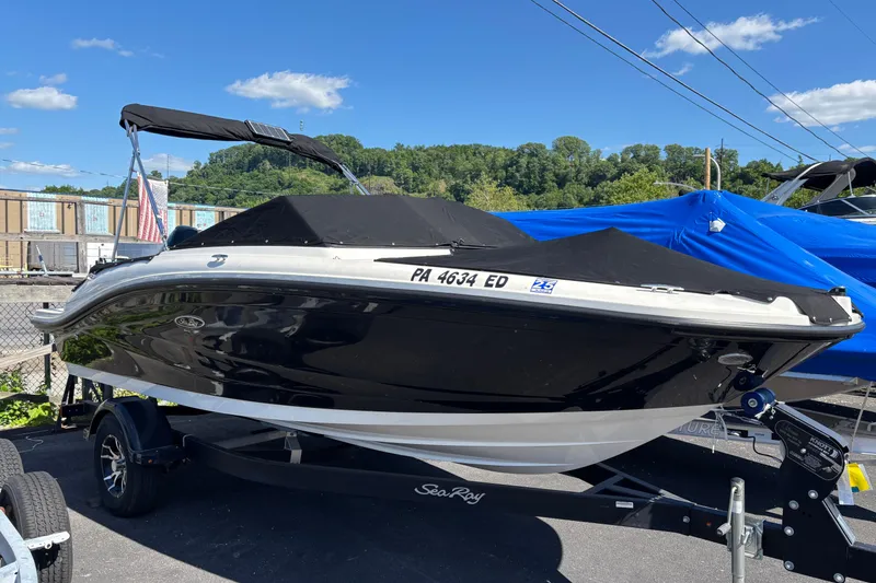 Slide: The Image of 2022 Sea Ray SPX 190 Outboard boat with black cover on trailer, sunny day. - 1