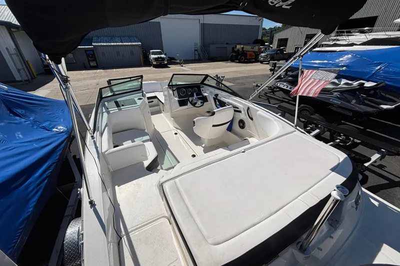 Slide: The Image of 2022 Sea Ray SPX 190 Outboard boat interior with seating and steering wheel, docked outdoors. - 3