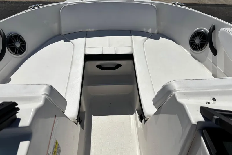 Slide: The Image of 2022 Sea Ray SPX 190 Outboard boat interior with white seating and speakers. - 7
