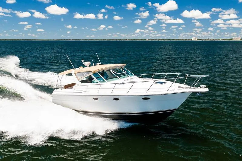 The Image of 2000 Tiara 3500 EXPRESS yacht cruising on open water under a clear blue sky. - 1