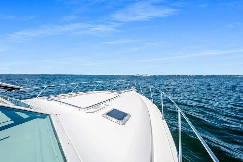 Slide: The Image of Bow view of 2000 Tiara 3500 EXPRESS yacht cruising on open water. - 11