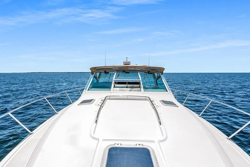 Slide: The Image of 2000 Tiara 3500 EXPRESS yacht cruising on open sea under clear blue sky. - 12