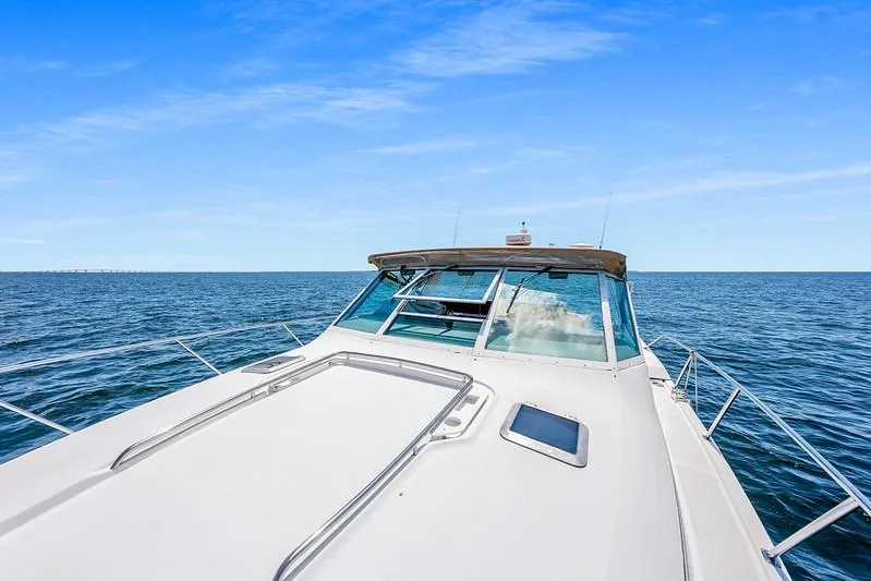 Slide: The Image of 2000 Tiara 3500 EXPRESS yacht cruising on open sea under clear blue sky. - 13