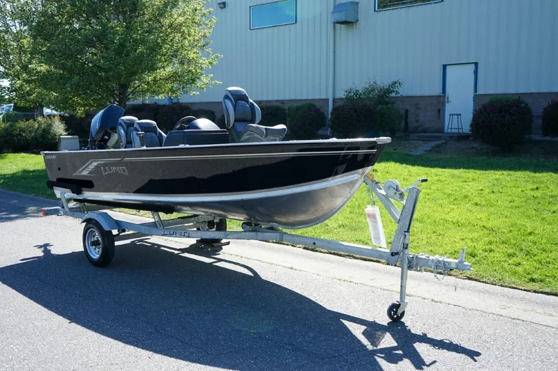 The Image of 2026 Lund 1400 Fury SS boat on trailer, parked outdoors near a building. - 0