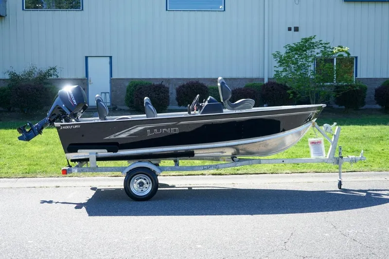 Slide: The Image of 2026 Lund 1400 Fury SS fishing boat on trailer, parked outdoors. - 1