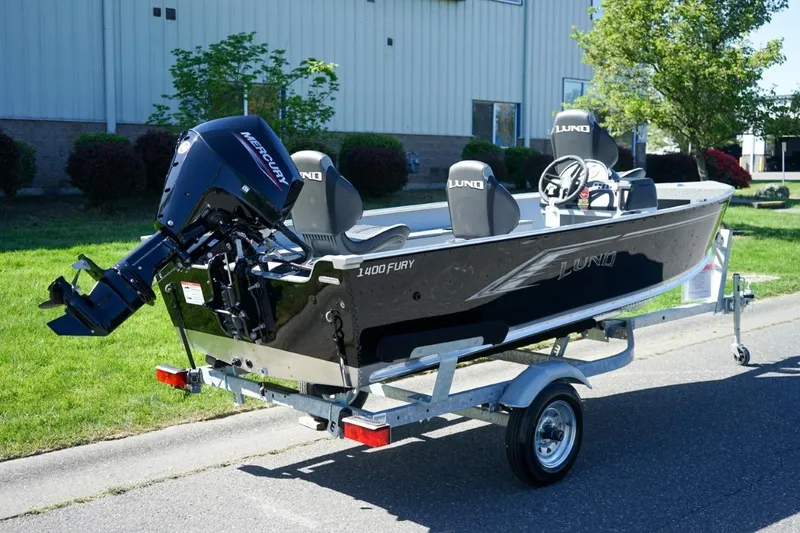 Slide: The Image of 2026 Lund 1400 Fury SS boat on trailer, featuring Mercury outboard motor. - 2