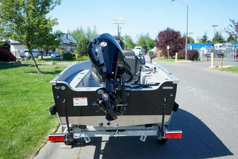 Slide: The Image of 2026 Lund 1400 Fury SS boat on trailer, parked on a sunny street. - 3